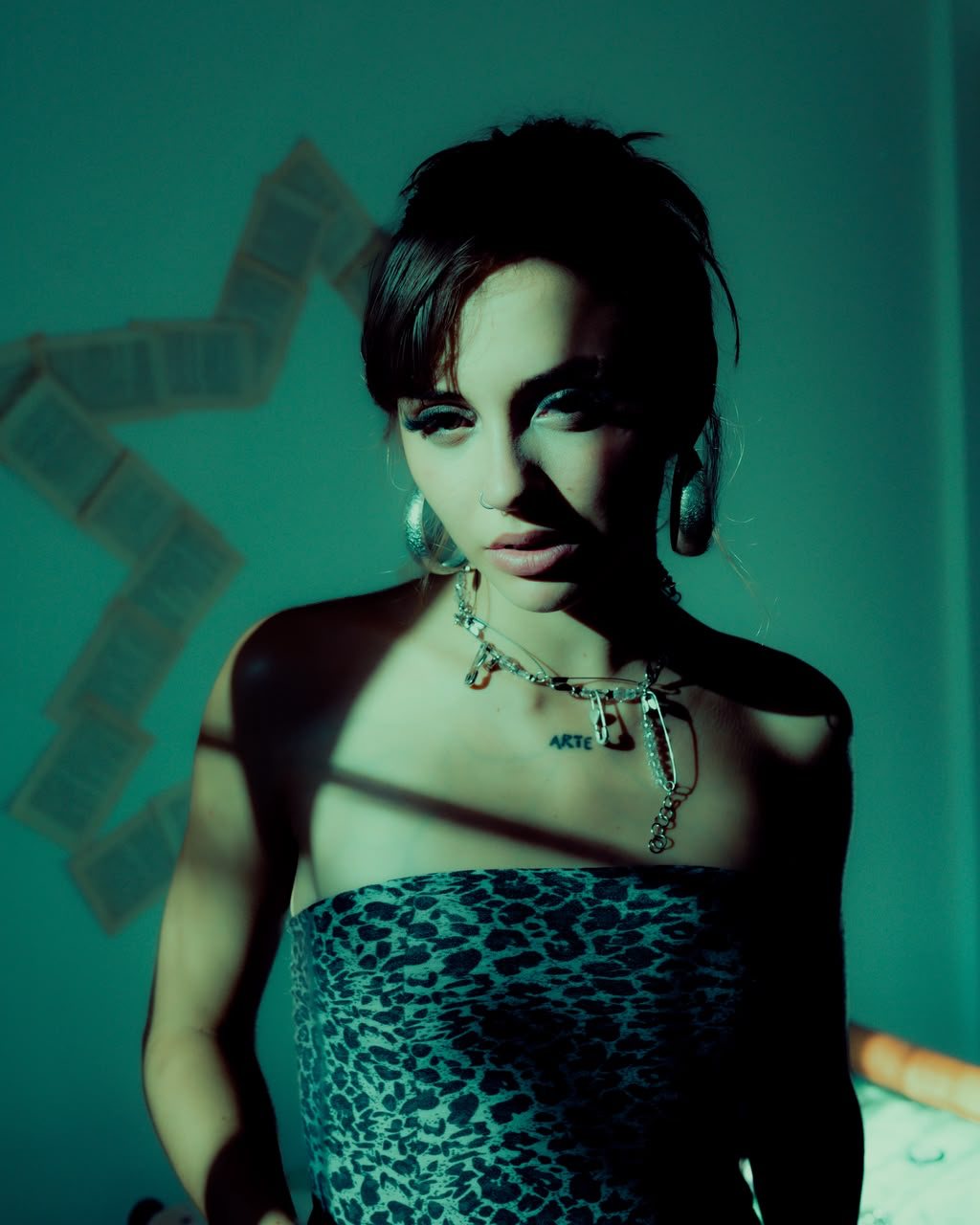 Retrato de Nena con top animal print bajo luz verde